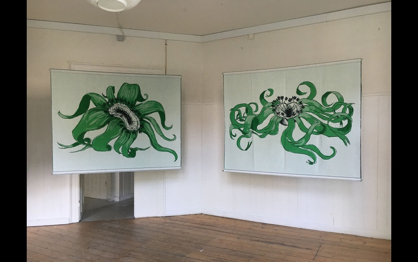 Kunstværker hængt op på væg og foran døråbning